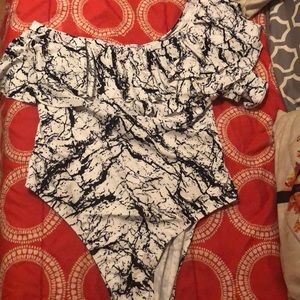 White and black one shoulder swimsuit with fringe